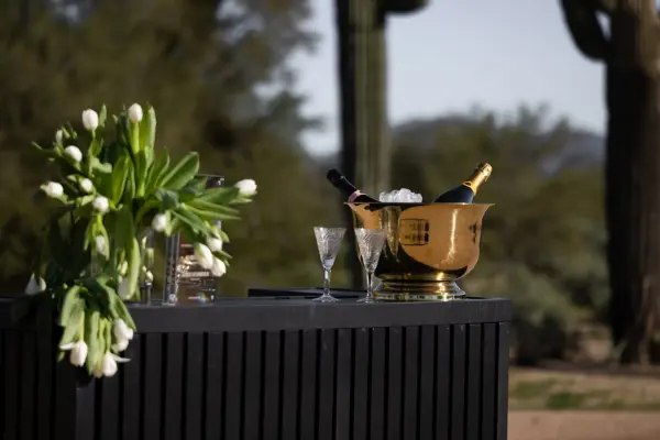 Bar cart topped with champagne and flowers