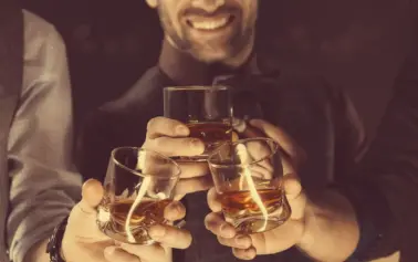 Groomsmen toasting whiskey in celebration