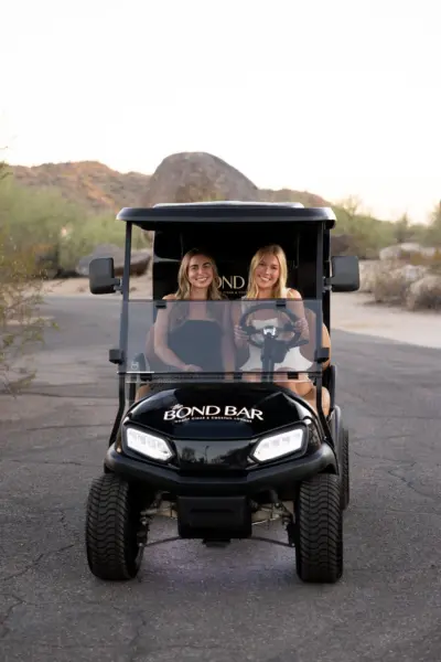 two girls driving golf cart humidor